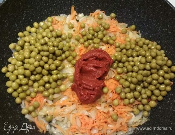 Отправьте в зажарку томатную пасту. Иногда я заменяю ее нарезанными помидорами или консервированными томатами в собственном соку. Добавьте сюда же консервированный горошек. Если не нравится вкус консервированного горошка, можно взять замороженный — суп приобретет нежный сладковатый вкус.