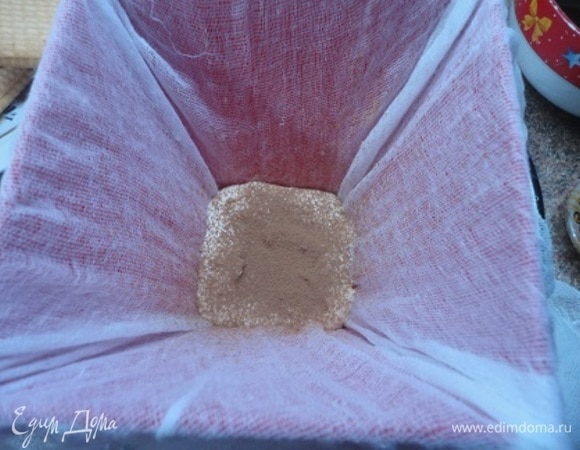 Добавьте к творогу жидкую заварную часть, соедините все компоненты блендером до однородной консистенции. Форму для пасхи ставим на тарелку и застилаем марлей. На самое дно выкладываем творожную массу, посыпаем какао.