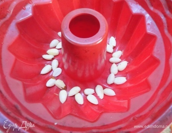 Изюм промыть и залить на 10 минут кипятком. С помощью кипятка очистить миндаль и выложить на дно формы. Подошедшее тесто смешать с изюмом и вылить в форму. Оставить для подъема на 25–30 минут.