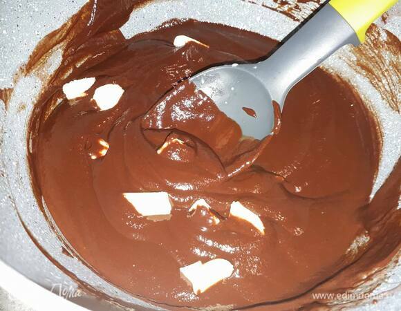 Вмешайте масло, нарезанное мелкими кусочками. Когда масло растопится, влейте вторую половину сливок и размешайте до однородного состояния.
