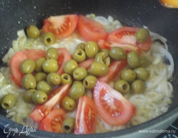 В этом же масле обжариваем сначала лук до прозрачности, затем добавляем чеснок, помидоры и оливки. Все вместе обжариваем минут 5, помешивая.