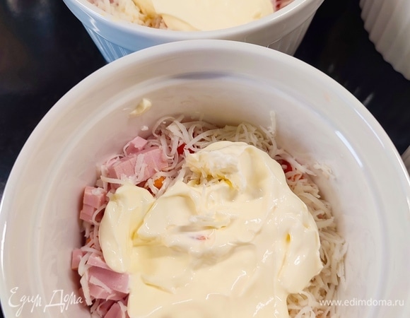 Сверху выложить по одной столовой ложке сметаны в каждую порцию.