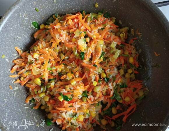 Лук очистить и мелко нарезать. Морковь очистить и натереть на терке. Сельдерей мелко нарезать. В сковороде разогреть растительное масло. Обжарить лук 1 минуту, добавить морковь и сельдерей. Обжаривать 3–4 минуты. Добавить в сковороду промытый рис, кукурузу, горошек и мелко порубленную кинзу, перемешать, чтобы рис пропитался маслом.