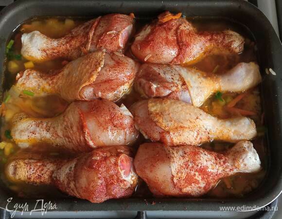 Переложить смесь в форму. Залить двумя стаканами кипятка или горячим бульоном. Курицу натереть со всех сторон солью, перцем и паприкой. Выложить на рис. Накрыть фольгой и поставить в духовку.