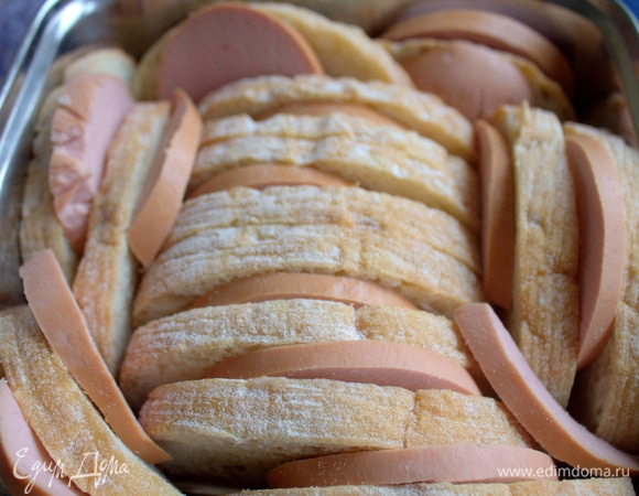 Поместить кружочки колбасы между хлебом. Сыр тоже нарезать, чередуя его с колбасой. 