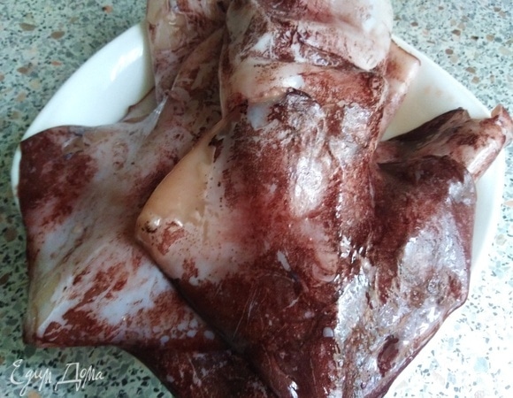 Подготовить кальмары. Опустить в кипяток на 30 секунд, а после — в холодную воду.