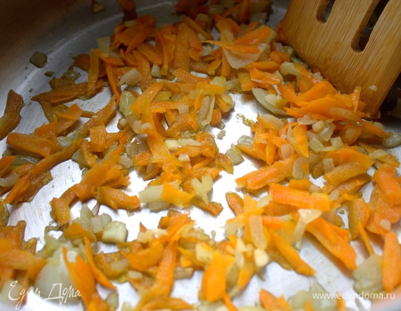 Морковь натереть и обжарить на оливковом масле с нарезанными луком и чесноком в кастрюле с толстым дном.