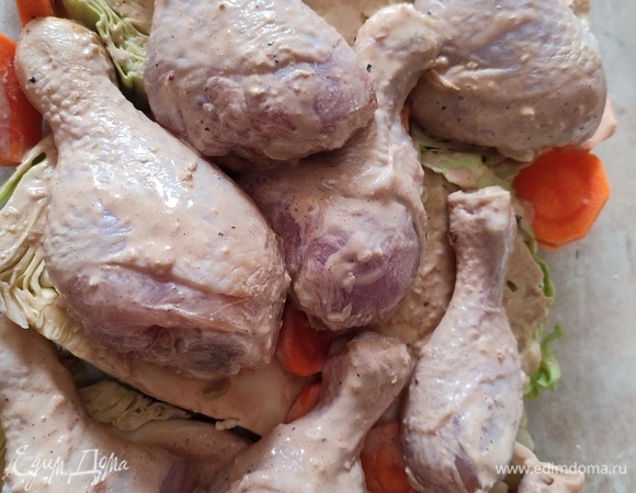 Смазать капусту маринадом и выложить сверху голени. Закрыть форму сверху фольгой. Запекать при температуре 200°C 20 минут под фольгой. Затем снять ее и запекать еще 20 минут.