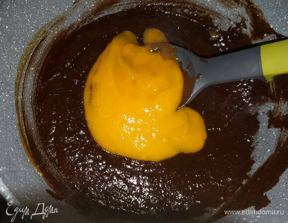 Влейте манговое пюре к шоколаду по частям, каждый раз размешивая до однородности.