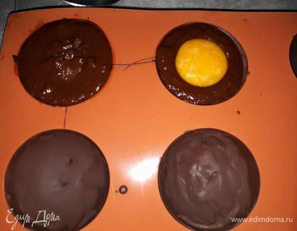 Влейте ганаш в скорлупки и поместите в центр по одной полусфере манго. Оставьте остывать до комнатной температуры, затем зафиксируйте в холодильнике полчаса.