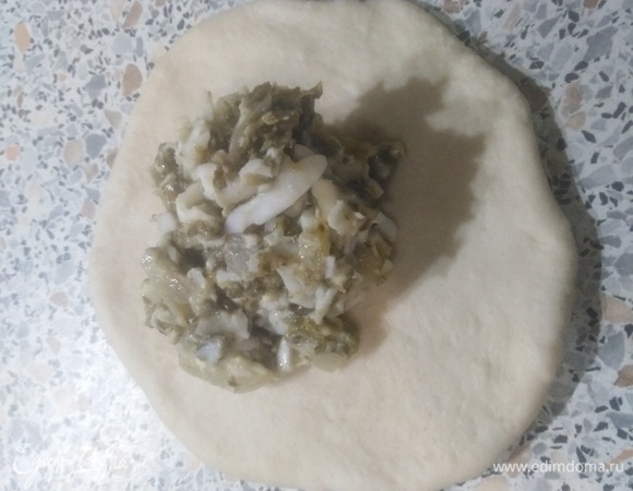 Каждую заготовку раскатать в лепешку. На середину выложить ложку начинки.