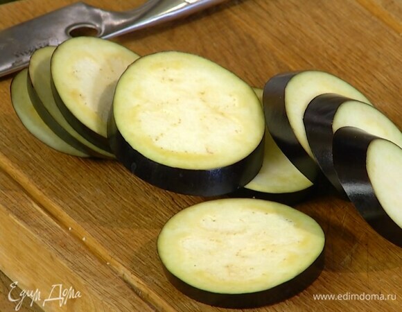 Баклажан, удалив плодоножку, нарезать кружками, выложить в миску, посыпать солью и дать постоять.