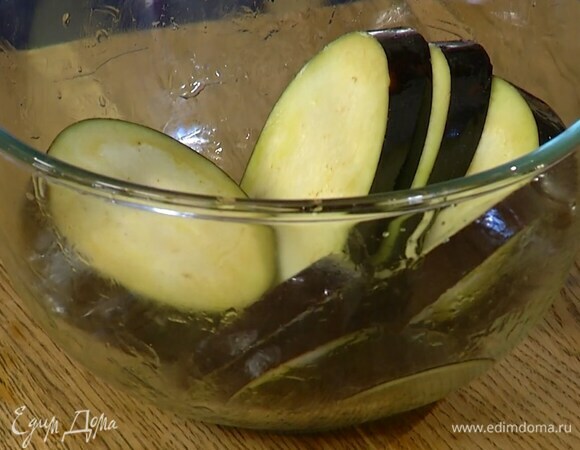 Промыть баклажаны от соли, просушить бумажным полотенцем и выложить в миску, затем полить оливковым маслом и перемешать.