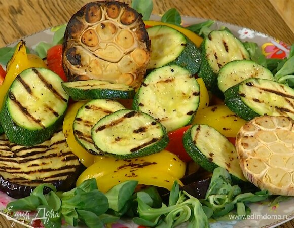 Все оставшиеся овощи обжарить на сковороде-гриль и выложить на салат вместе с запеченным чесноком.