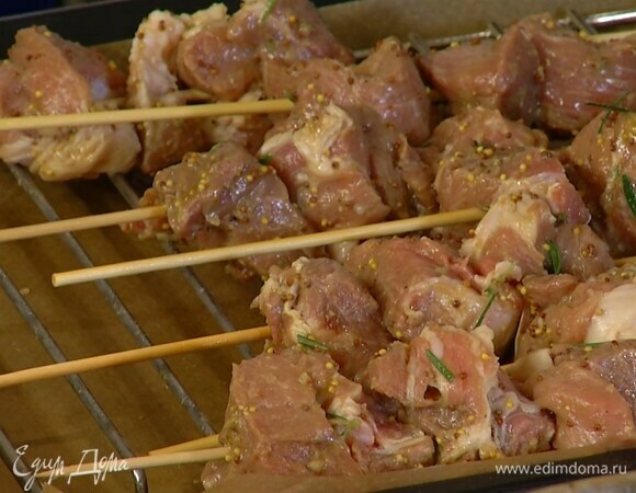 На выстеленный бумагой для выпечки противень поместить решетку для гриля, сверху разложить шпажки с мясом.