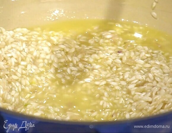 Приготовить тостатуру: рис всыпать в сковороду с луком и, помешивая, прокалить его, влить 100 мл вина и дать алкоголю выпариться, затем по одному половнику вливать горячий бульон.