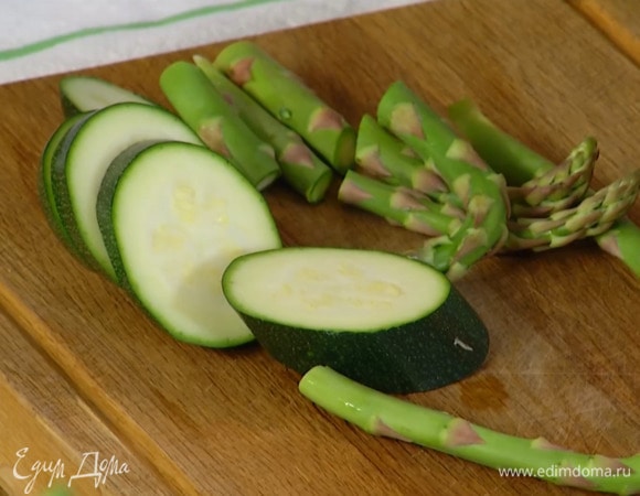 У спаржи удалить грубые черенки и разрезать ее на 2 части.