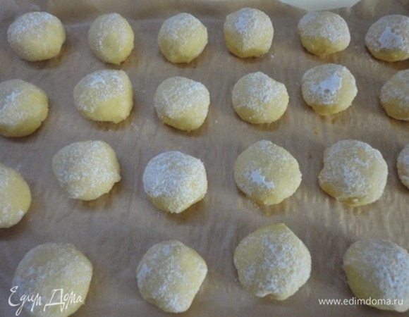 Скатать шарики величиной с крупный грецкий орех, обвалять в сахарной пудре и выложить на противень. Выпекать 20–25 минут при 180°C.