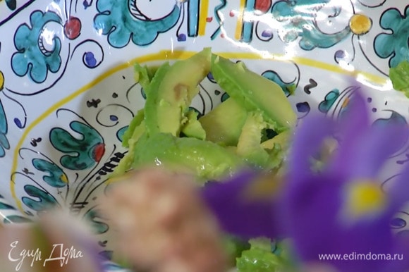 Авокадо почистить и, удалив косточку, нарезать небольшими ломтиками и выложить в салатник.