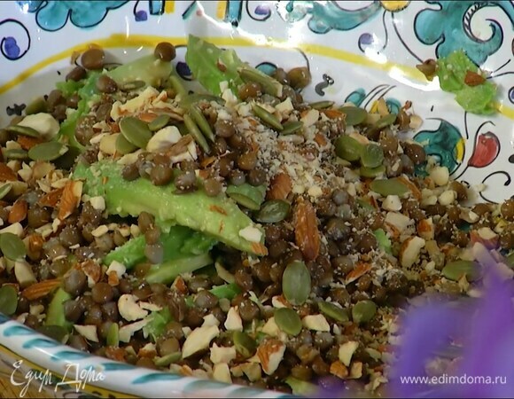 Полить авокадо выжатым из половинки лимона соком, добавить готовую чечевицу, посыпать все измельченными орехами и половиной семечек.