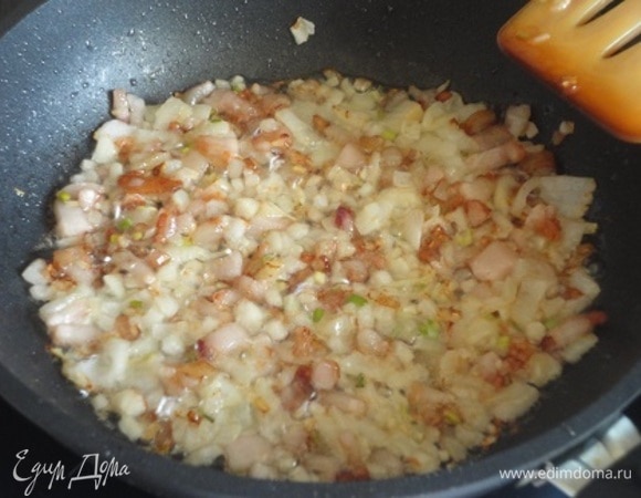 Рис отварить в подсоленной воде до полуготовности и откинуть на сито. Лук и чеснок мелко нарубить и обжарить 2 минуты.