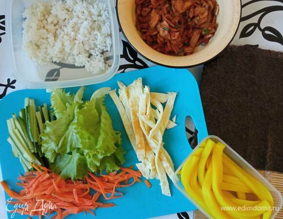 Морковь трем на терке для корейской моркови или режем тонкой соломкой. Заливаем морковь горячей подсоленной водой и даем постоять минут 10. Сливаем воду и обсушиваем морковь. Огурец режем на тонкие брусочки. Середину огурца не используем. Моем и обсушиваем несколько листьев салата.