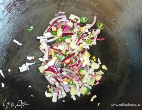 Морковь, сладкий перец и сельдерей (большую часть) нарезаем соломкой. Лук — полукольцами. Чеснок, перец чили и часть сельдерея мелко рубим. На хорошо прогретый вок наливаем растительное масло и 1 ст. л. кунжутного масла, бросаем чеснок, сельдерей (мелко рубленный), чили и лук, перемешиваем. Жарим 1 минуту.