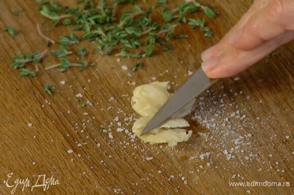 Чеснок почистить и вместе с солью растереть плоской стороной ножа в пасту, затем добавить листья тимьяна и еще немного растереть.