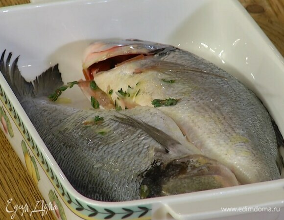 Дораду выложить в жаропрочную керамическую форму и смазать внутри чесночной смесью.