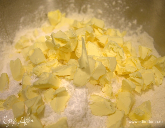 Холодное масло порубить в муку с мелкой солью, сахарной пудрой и разрыхлителем.