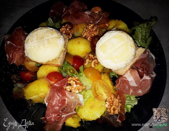 Выложите на тарелку салатные листья, помидоры, картофель и орехи. Заправьте винегретом. Добавьте готовый багет с сыром и ветчину.
