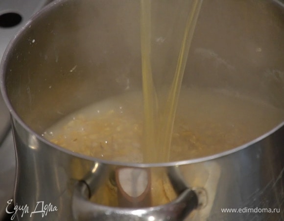 Когда вода практически выкипит, влить горячий куриный бульон, так чтобы крупа была покрыта на полтора пальца, всыпать сванскую соль и перемешать.