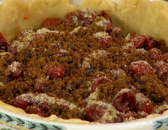 В жаропрочную керамическую форму выложить 2/3 теста и сформировать корж с бортиками, сверху разложить вишню, полить ее ванильным экстрактом, посыпать корицей, измельченным миндалем и сахаром.