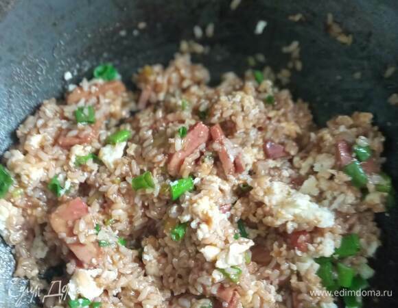 Добавляем рис, разбиваем комочки и хорошо перемешиваем. Готовим 2–3 минуты до почти полного исчезновения жидкости. Постоянно помешиваем, чтобы ускорить этот процесс и не дать рису пригореть. Возвращаем в сковороду яйца, перемешиваем, добавляем зеленый лук и еще раз перемешиваем. Если вам мало соли, досаливаем. Выключаем нагрев. Простое и вкусное блюдо готово.