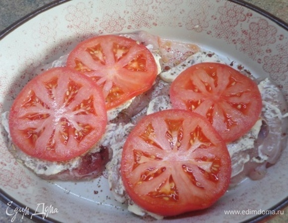 Куриные грудки выложить в форму для запекания, смазать майонезом и накрыть кружочками томатов.