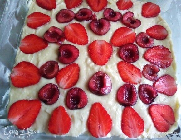 Выложить в смазанную сливочным маслом форму. Разровнять. На тесто уложить ягоды срезом вверх.