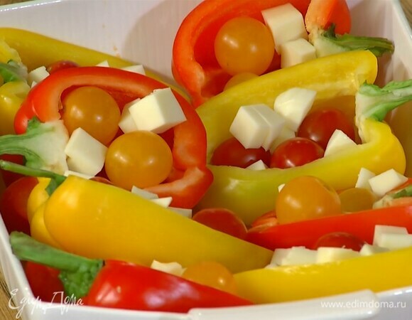 Моцареллу нарезать небольшими кубиками и выложить на помидоры.