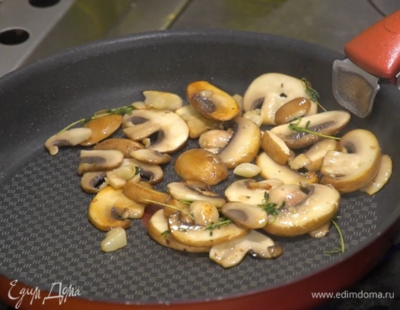 Разогреть в отдельной сковороде 1 ст. ложку оливкового масла, выложить чеснок, веточки тимьяна и грибы, все посолить и обжарить.