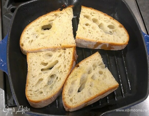 Готовые колбаски снять со сковороды-гриль, поместить в нее хлеб, сбрызнуть оставшимся оливковым маслом и обжаривать до появления румяных полосок.