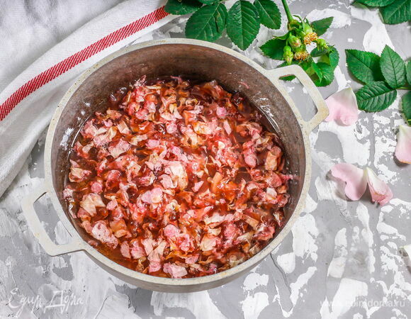 Сварите сироп: смешайте в кастрюле воду и сахар. Помешивая, доведите до кипения, варите до легкого загустения. <br />
Добавьте лепестки, перемешайте и всыпьте лимонную кислоту на кончике ножа. Перемешайте еще раз и варите 10 минут.