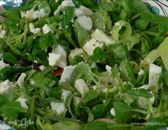 Полить заправкой салат, сверху разложить поломанную на кусочки фету.