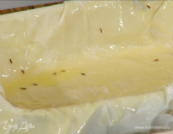 В жаропрочную керамическую форму выложить три-четыре листа фило, промазывая каждый сливочным маслом (края теста должны свешиваться).