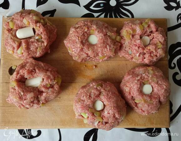 Теперь нужно скатать 8 шариков. В середине каждого делаем углубление и кладем кусочек сыра. Слегка вдавливаем и закрываем углубление.