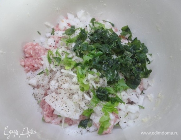 К фаршу добавьте лук с чесноком и зеленью. Посолите, поперчите, хорошо перемешайте.