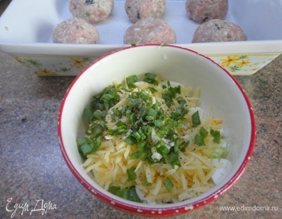 Отваренные вкрутую яйца мелко нарубите и смешайте с натертым сыром и рубленым зеленым луком.