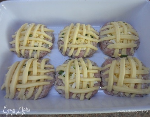 В каждое углубление положите начинку. Из полосок слоеного теста выложите сверху решетку. Смажьте их желтком и запекайте в духовке при 180–190°C 25–30 минут.