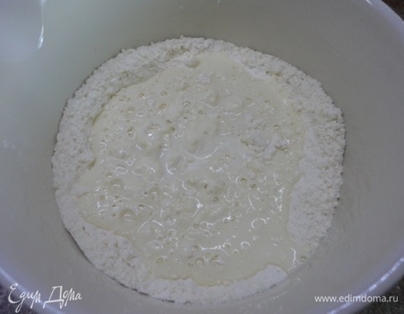 Холодное сливочное масло перетереть с мукой и разрыхлителем в масляную крошку. Сметану смешать с яйцами, солью, сахаром, ледяной водой и вылить в масляную крошку.