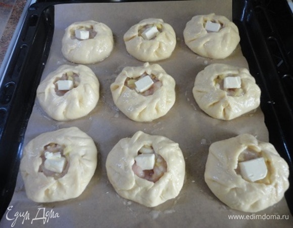 Данное количество теста я делю на 10 равных частей. Каждую часть раскатываю в кружок (края потоньше), на середину выкладываю начинку и защипываю края. Выкладываем на противень, смазываем яичным желтком, смешанным с молоком, и в каждый мини-курник кладем по кусочку сливочного масла.