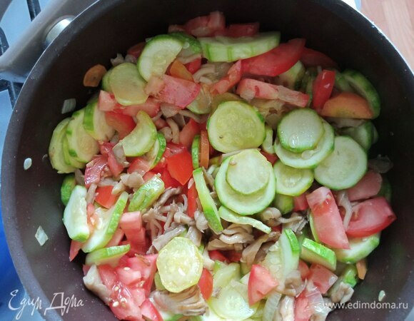 Морковь режем полукольцами, помидоры — кубиками. Морковь и помидоры добавляем в сотейник. Обжариваем все вместе минут пять.