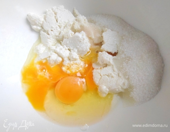 В творог добавить яйца, сахар и ваниль.